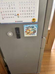 冷蔵庫に貼りついたシーリングファンのリモコンと扇風機のリモコン