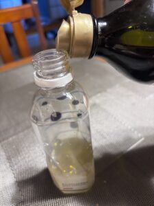 ペットボトルにオリーブオイルを注ぐところ