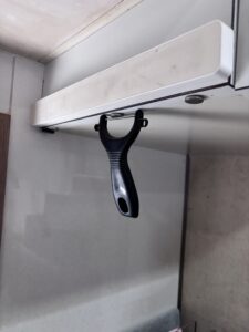 ピーラーが丸い磁石で下側面からぶら下がっている様子