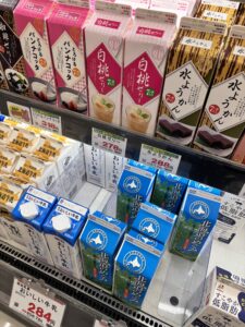 牛乳やゼリーの棚。賞味期限のラベルが並んでいる