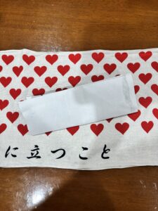 広げた手ぬぐいの真ん中に紙袋を置いたところ