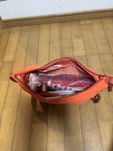 オレンジ色のショルダーバッグ