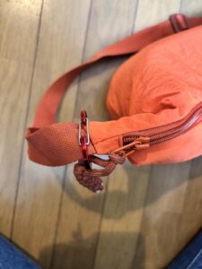 斜め掛けにしたオレンジのバッグ
